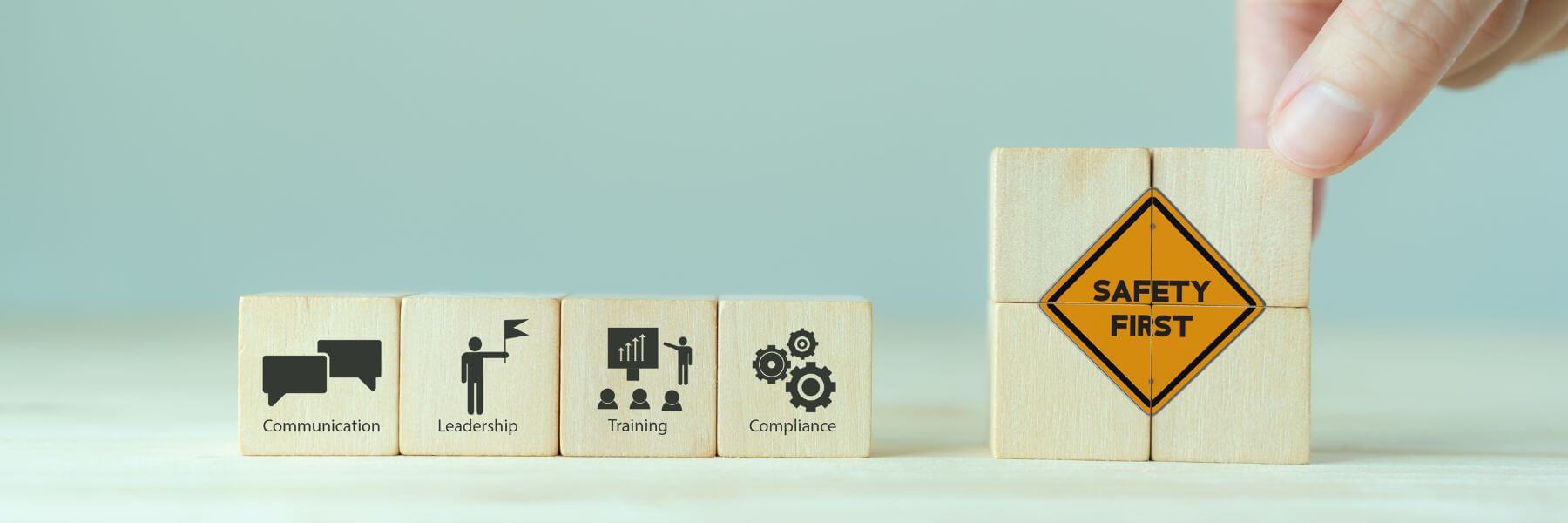 wooden cubes with safety first and icons communication, leadership, training and compliance