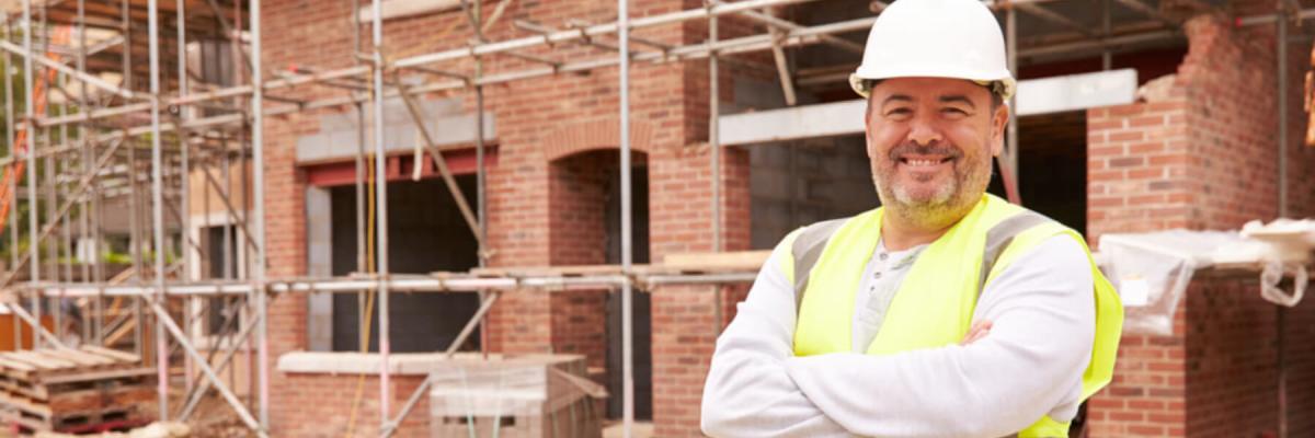 Construction worker standing with arms crossed at worksite