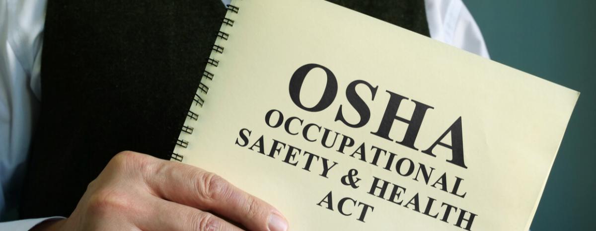 Man in suit holding OSHA booklet for training