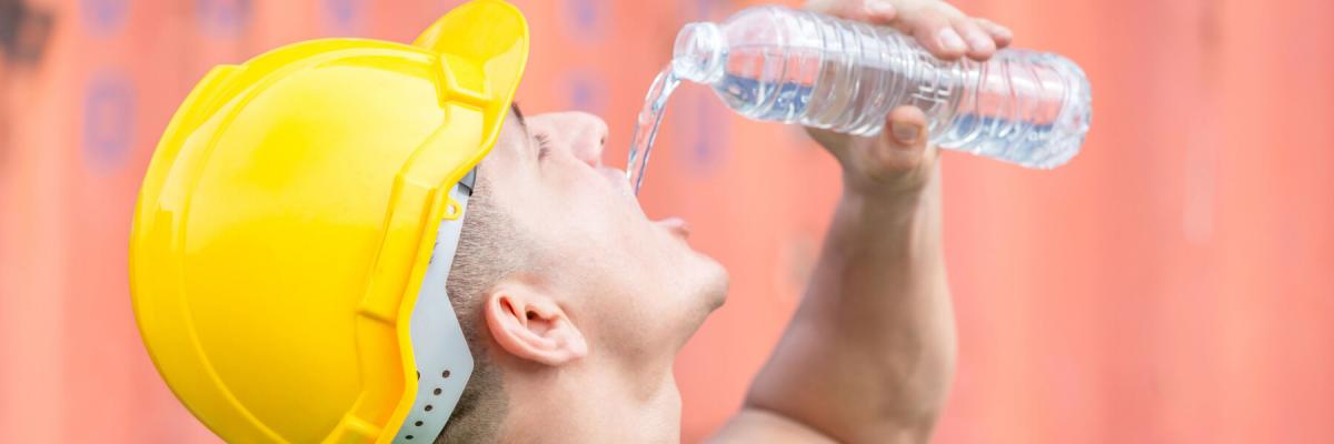 worker in hard hat drinking bottle of water