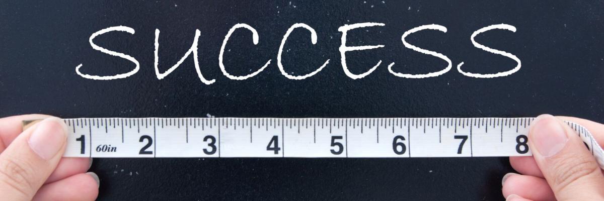 measuring tape under Success written on chalkboard