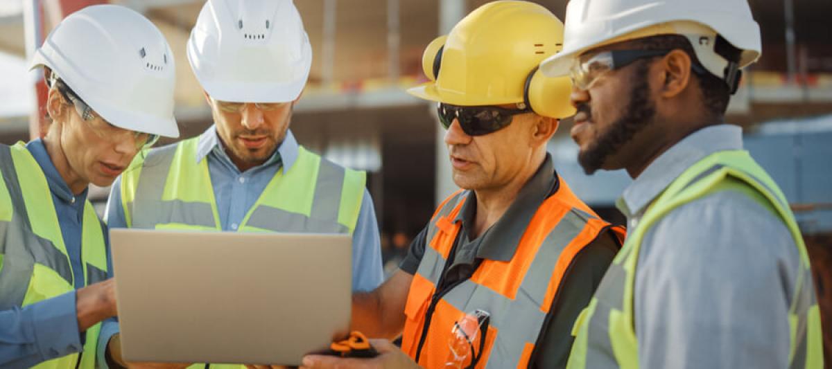 Group of construction workers holding a safety meeting on work site