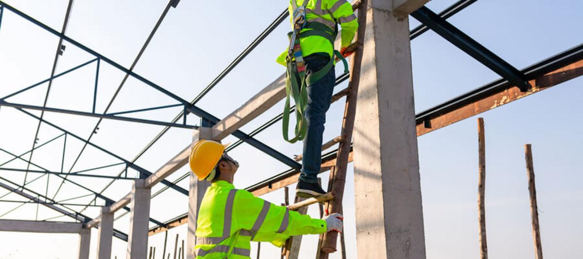construction workers applying ladder safety procedures